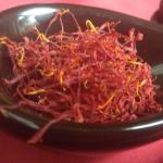 greek grown saffron filaments on black spoon